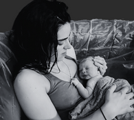 a mum holds her newborn inside a birthing pool - mumfulnes.me doula in helsinki and espoo